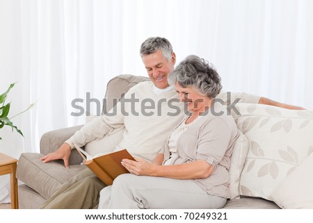 Senior couple looking at their photo album at home