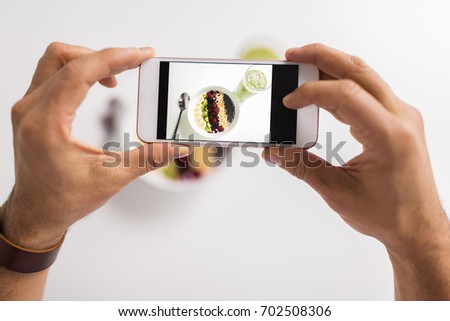 healthy eating, people and technology concept - hands photographing breakfast by smartphone