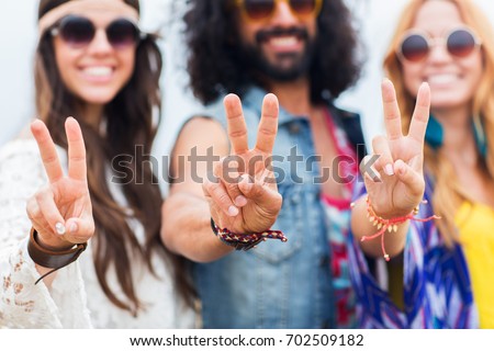 youth culture, gesture and people concept - smiling young hippie friends in sunglasses showing peace hand sign outdoors Royalty-Free Stock Photo #702509182