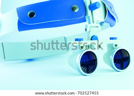 Photo dental instruments mirror, probe, tweezers, mask, binocular glasses magnifier, model of human jaw placed on white background