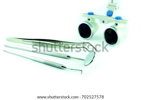 Photo dental instruments mirror, probe, tweezers, mask, binocular glasses magnifier, model of human jaw placed on white background