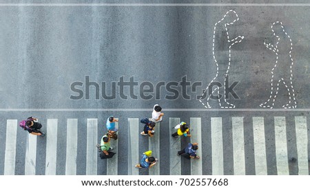 the top view of group people walk on crosswalk pedestrian walkway with the white signage symbol dot of people walk and use mobile phone on the road
