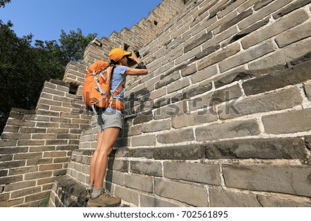 young woman photographer taking photo on great wall
