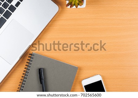 laptop computer, cell phone and notebooks with pen on wooden office desk, top view with copy space