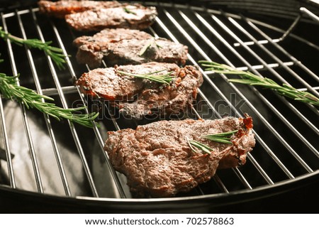 Tasty steaks with rosemary on barbecue grill