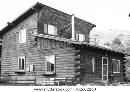 A black and white picture of a log cabin.