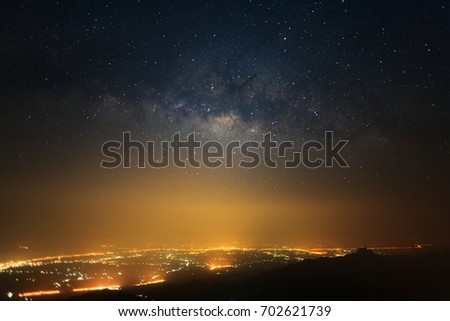 milky way galaxy with stars and space dust in the universe and city light at Phutabberk Phetchabun in Thailand.