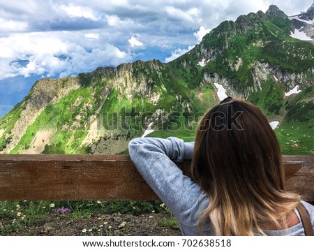 the girl looks at the mountain