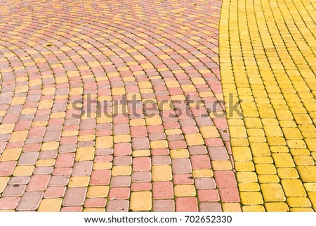 Paving slabs by mosaic close-up. Road paving, construction . Fixed tessellated sidewalk tile. Colored concrete paving slab
