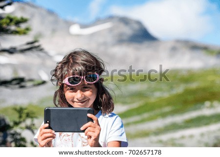 Happy young girl making selfie hiking mountain peak.