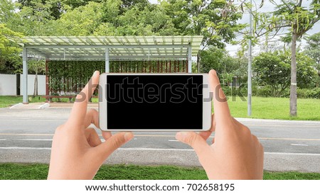 woman use mobile phone and the empty public rest-house in the park with many trees