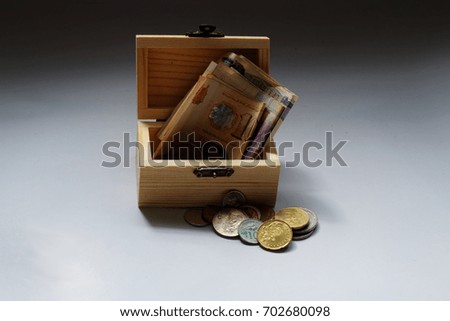 Box filled with money and coin in different currency. Conceptual.