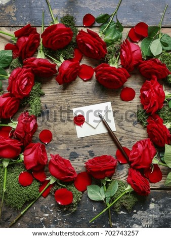 Red roses on wooden background, copy space.