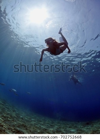 free diver girl underwater with sun