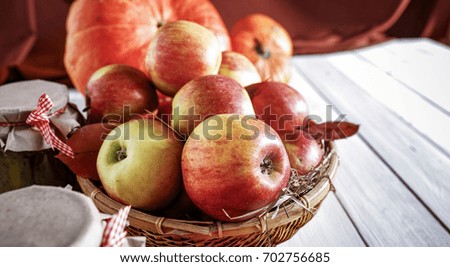 Juicy apples in a basket on a white wooden table in the morning sunlight