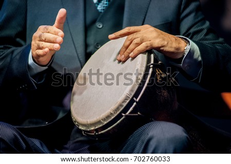 Hands of men playing on the drum