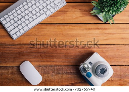 office desk instant camera and keyboard on wood table