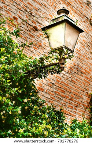 the photo of italian narrow street with the street lantern in the summer