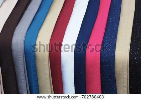 Different color textile fabrics clothes lay in row