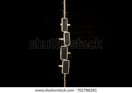 Blank blackboard wooden peg tags hanging from jute rope