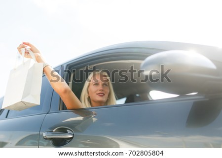 Blonde with shopping in car