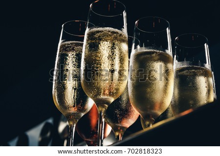 a row of glasses filled with champagne are lined up ready to be served Royalty-Free Stock Photo #702818323