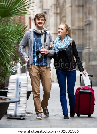 Young man and positive woman with photo camera studying neighborhood