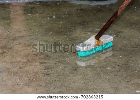 Cleaning dirty floor with brush and washing powder.