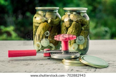 semi-automatic capping machine and jars with pickled cucumbers