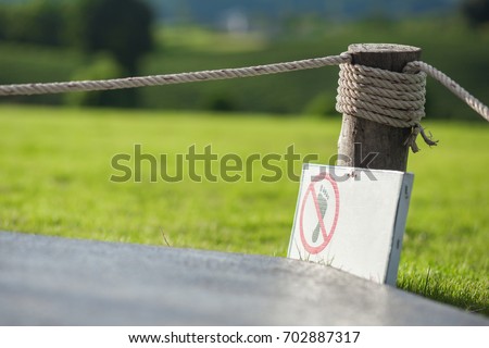  Do not step on grass, rope barrier, green grass.