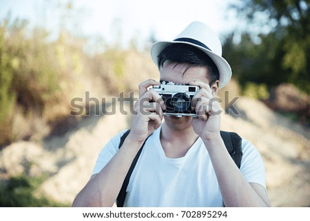 Young man with retro camera taking photos