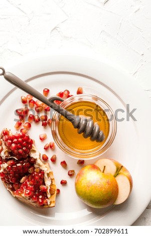 Halves of apples with honey, pomegranate seeds on a large plate