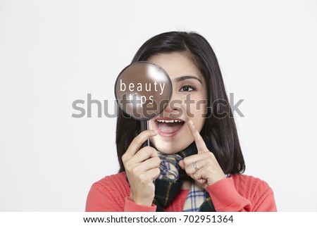 asian woman holding a magnifying glass