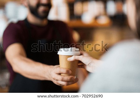 small business, people and service concept - man or bartender serving customer at coffee shop Royalty-Free Stock Photo #702952690