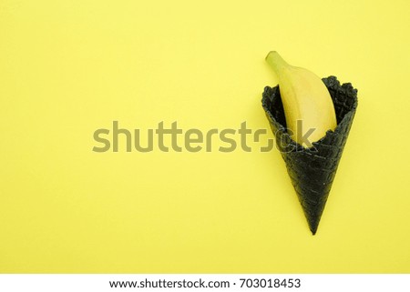 Black ice cream cone with banana