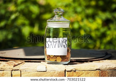The bottle,jar with money and coins with cap closes with blurry background.Saving is for the education for future. Financial concept.Copy space.place for text.Outdoor.