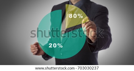 Unrecognizable manager with marker in hand approaching virtual pie chart illustrating the Pareto principle. Business concept for 80 - 20 rule, law of the vital few and principle of factor sparsity. Royalty-Free Stock Photo #703030237