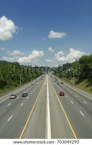 A six-lane interstate highway with divider.  Lots of travelers on a late summer day. US Highway 640 in Knoxville, Tennessee, USA. Royalty-Free Stock Photo #703049290