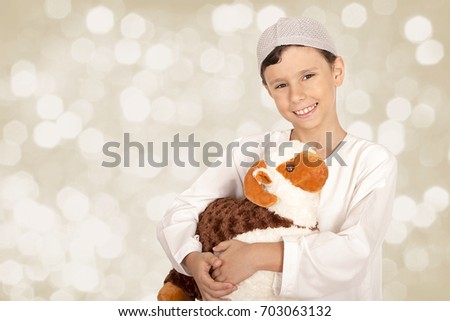 Happy little boy playing with his sheep toy - celebrating Eid ul Adha - Happy Sacrifice Feast Royalty-Free Stock Photo #703063132