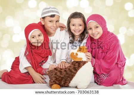 Happy little Muslim kids playing with sheep toy - Family celebrating Eid ul Adha - Happy Sacrifice Feast Royalty-Free Stock Photo #703063138