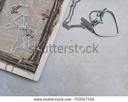 Christian cross necklace with heart shape necklace on grunge floor