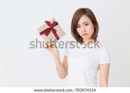 young attractive asian woman who thinks while having a present