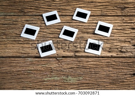 Top view film slide with notebooks on rough wooden background. Film slide background.