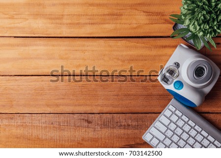 creative desk instant camera and office keyboard on wood table