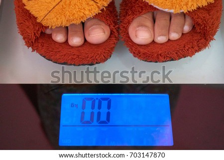 Measure your weight. Kids with soft in house shoes on a digital scale.