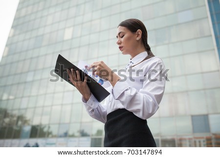 Business woman stands on the background of business center.