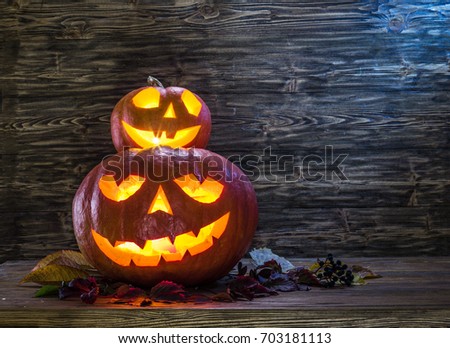 Grinning pumpkin latern or jack-o'-lantern is one of the symbols of Halloween. Halloween attribute. Wooden background.