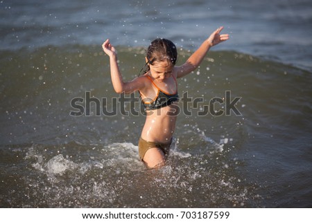 Little girl playing and swimming in the sea