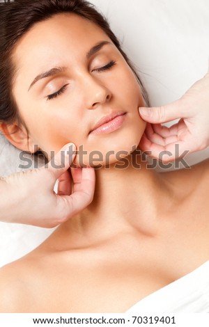 pretty woman receiving face massage, closeup photo