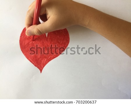 A child drawing a red heart